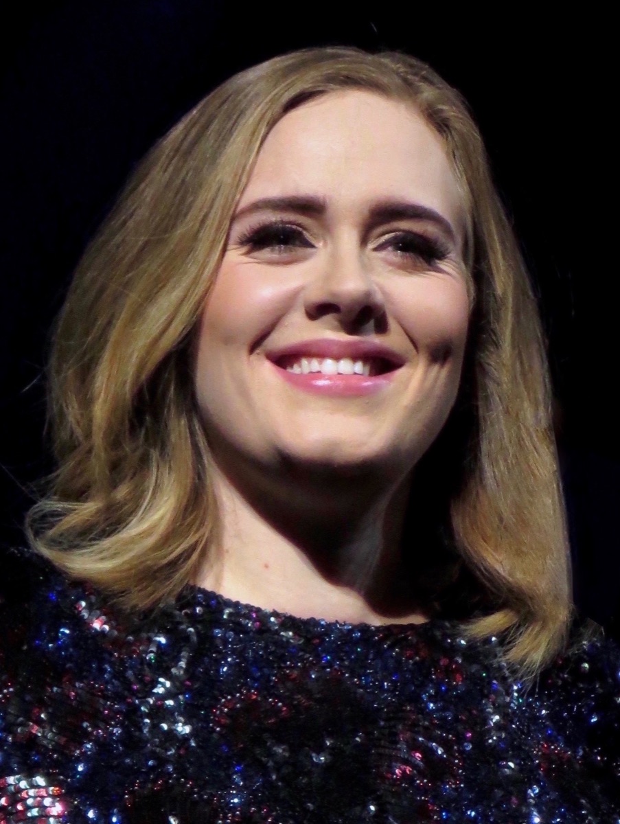 Adele sorride sul palco della SSE Hydro di Glasgow nel 2016