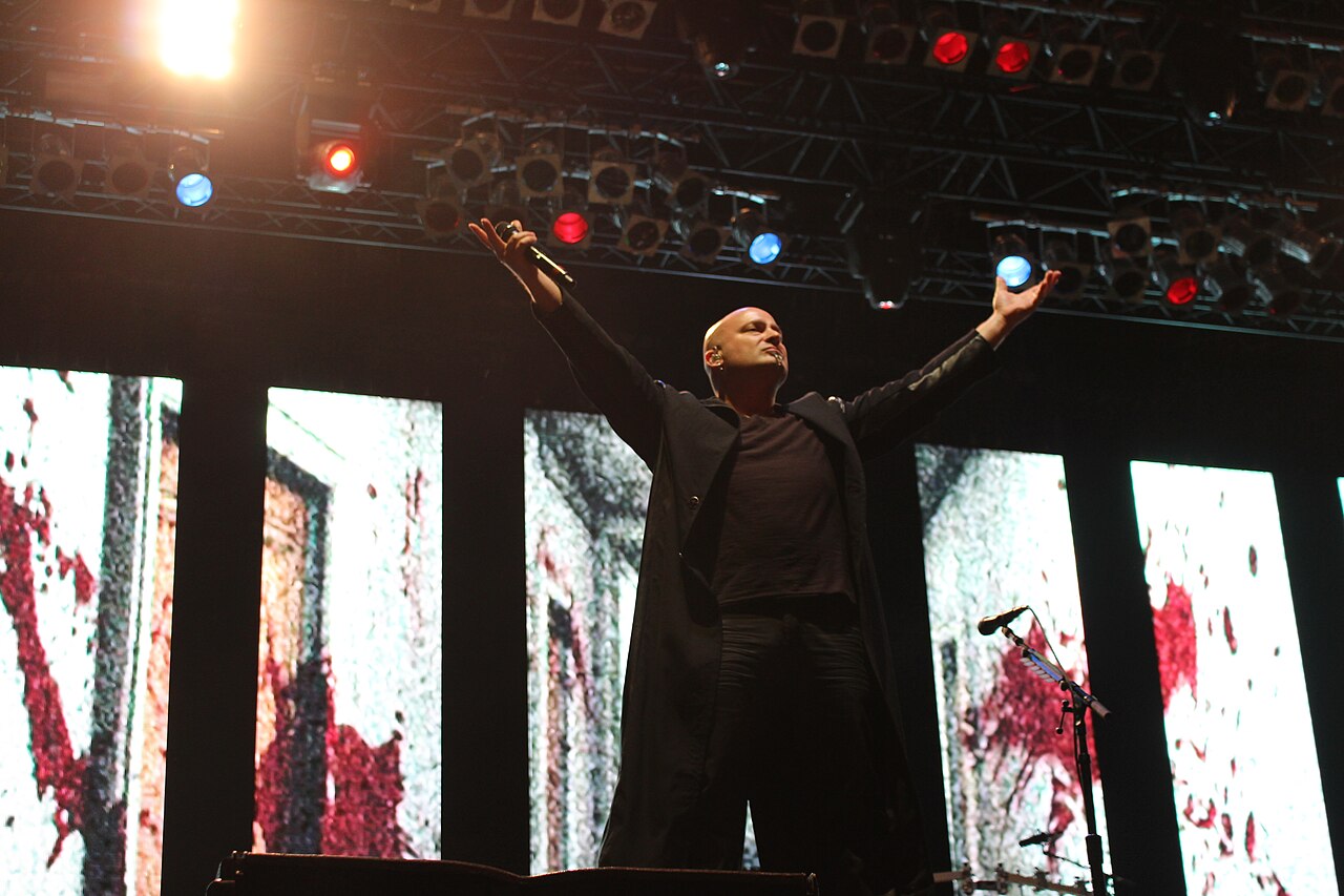 David Draiman dei Disturbed sul palco del Nova Rock nel 2016, con le braccia alzate