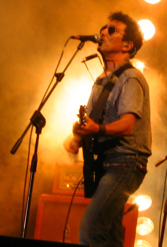 Edoardo Bennato canta al microfono con la chitarra durante un concerto nel 2007