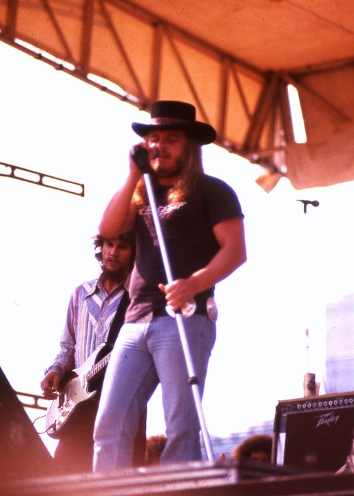 Ronnie Van Zant dei Lynyrd Skynyrd canta sul palco con il microfono durante un concerto del 1977