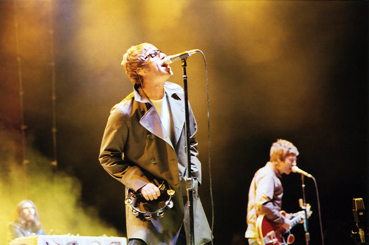 Liam Gallagher canta al microfono e Noel Gallagher suona la chitarra durante un concerto degli Oasis a San Diego nel 2005
